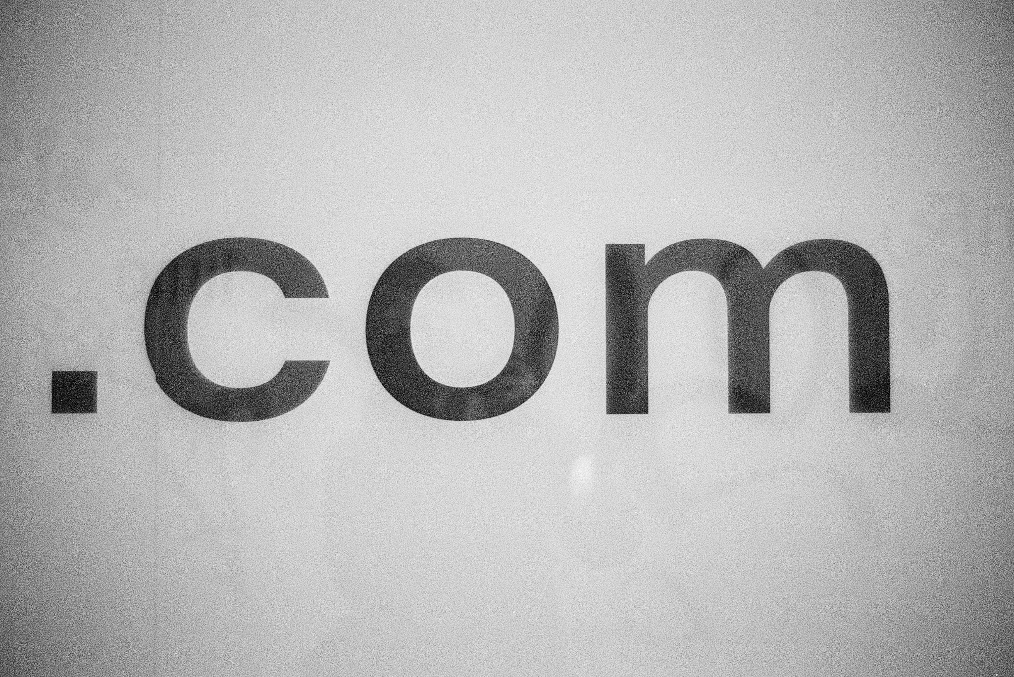 Close-up monochrome .com domain lettering representing domains and hosting