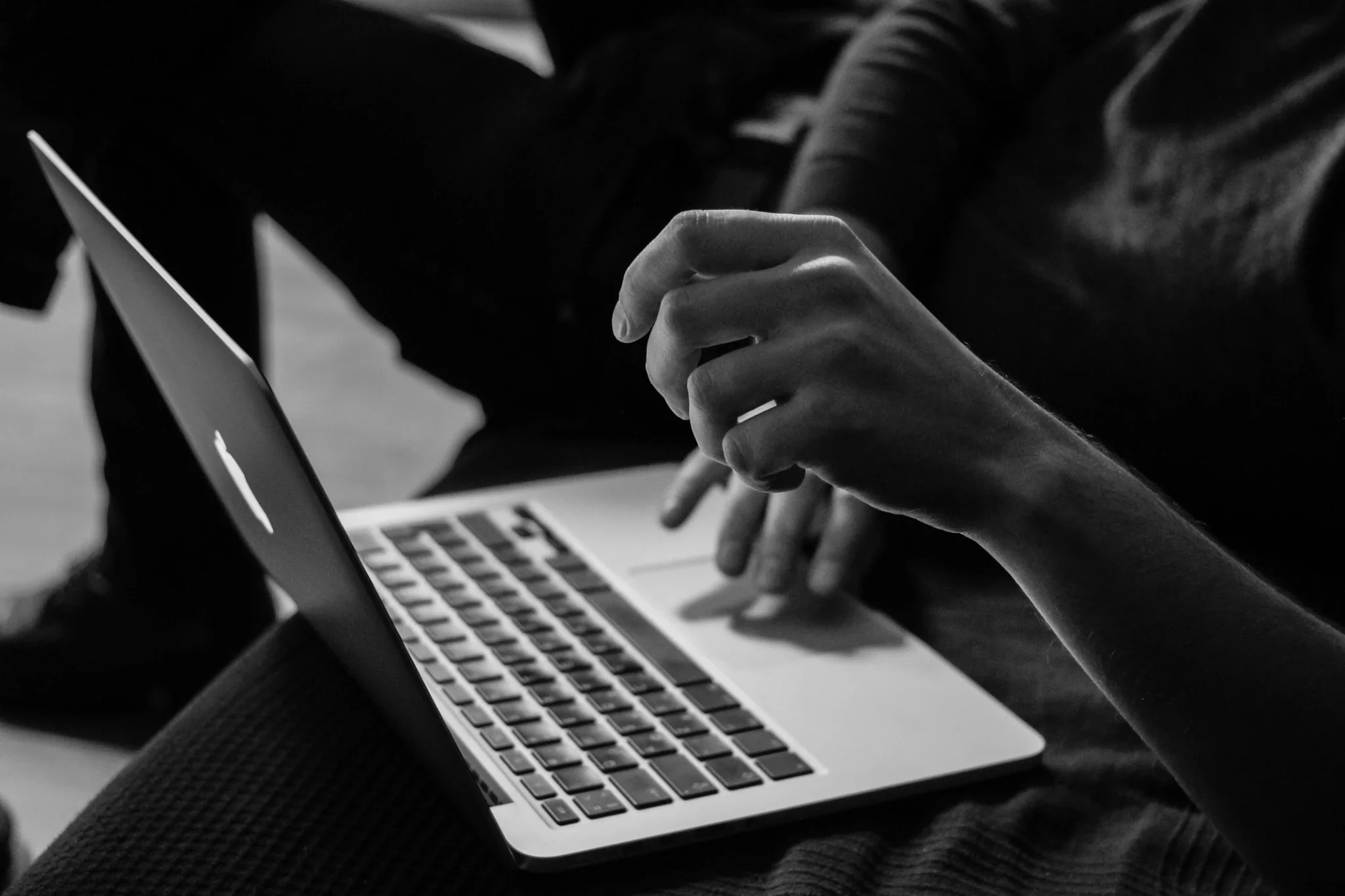 Monochrome laptop and hands representing web design and digital work